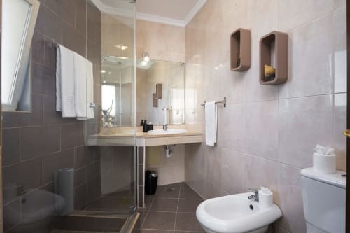 Modern bathroom with walk-in shower, vanity sink, and toilet at RB Algarve hotel apartment in Vilamoura, Portugal
