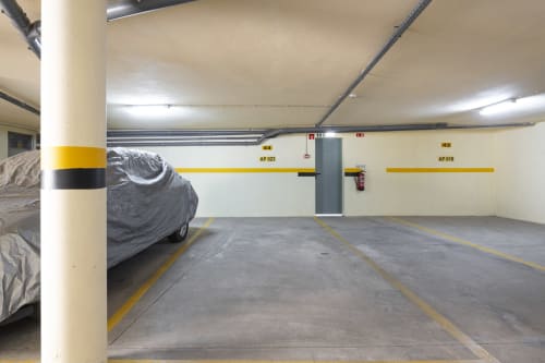Underground parking garage at RB Algarve hotel with covered car, yellow markings, and concrete spaces in Vilamoura, Portugal