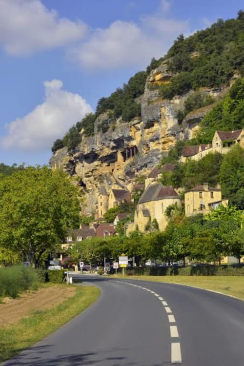 Route menant aux Gîtes Le Pech avec bâtiments à flanc de falaise à Sainte-Foy-de-Longas, France