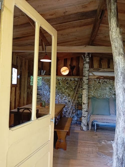Chambre de cottage Les Tramois à Donzy avec porte jaune, poutres en bois et vue sur le jardin