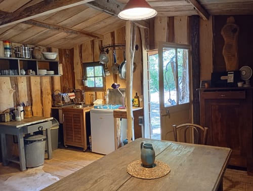 Intérieur rustique du gîte Les Tramois à Donzy : cuisine, table à manger et vue sur le jardin