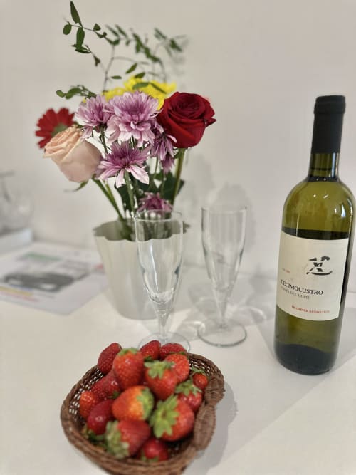 Benvenuto in camera Deluxe presso St Mary Major Loft Roma: bottiglia di vino, fragole fresche, fiori colorati e calici di vino