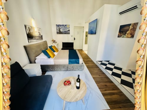 Camera Quadrupla Deluxe presso St Mary Major Loft Roma con letto matrimoniale, zona living, bottiglia di vino e vista sulla città