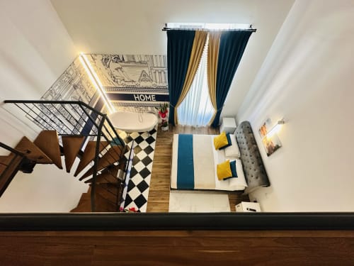 Vista dall'alto della suite familiare superior di St Mary Major Loft a Roma con letto, scala a spirale e tende con vista sulla città