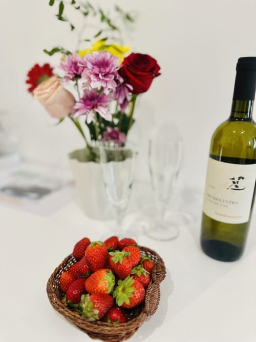 Bottiglia di vino, fragole fresche e fiori colorati su tavolo bianco presso St Mary Major Loft Roma