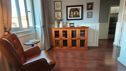 Salón biblioteca Mirador Medieval con sillón de cuero, mueble de madera y cuadros en Cáceres