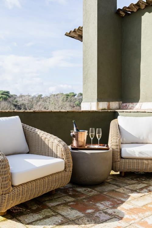 Terraza del hotel Mas Escarrà con sillas de mimbre, champagne y vistas al campo de Caldes de Malavella