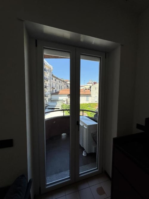 Porte del balcone dello studio alle Muratori Apartments Milano, vista sui palazzi della città e terrazza con verde