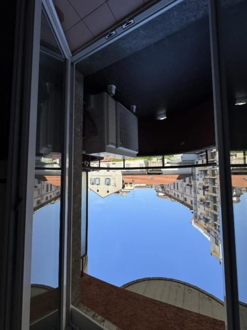 Vista dal balcone della corte milanese di Muratori Apartments con edifici storici e cielo azzurro