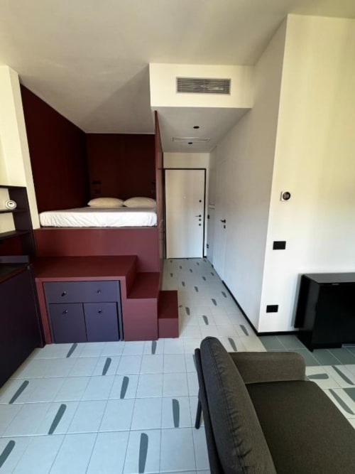 Monolocale ai Muratori Apartments Milano con letto a soppalco, divano e arredi moderni