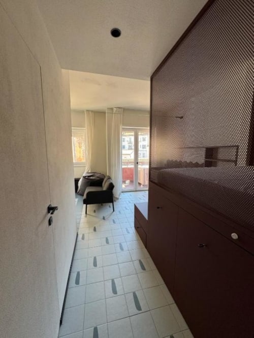 Corridoio moderno dello studio presso Muratori Apartments Milano con armadi scuri e pavimento in piastrelle