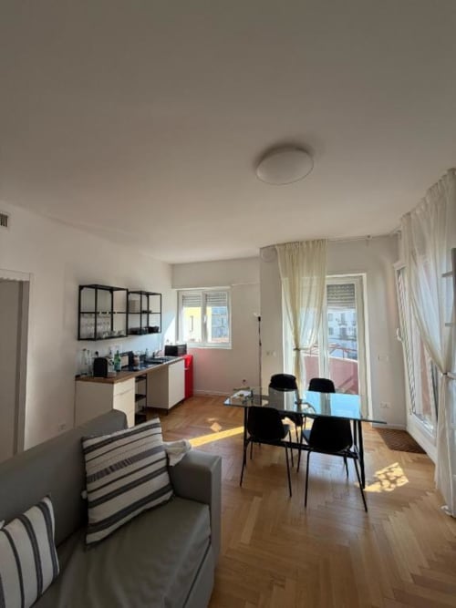 Appartamento moderno con tre camere a Milano, zona living open-plan, sala da pranzo, cucina, accesso alla terrazza e pavimenti in legno