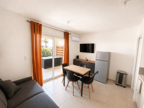 Séjour ouvert et moderne à l'appartement Casa Di Bravone avec table à manger, TV, kitchenette et accès balcon avec vue