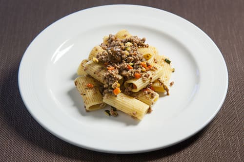 Rigatoni al ragù di carne e verdure su piatto bianco all'Hotel Ristorante alle Querce di Castelbuono