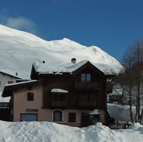 Al Dos hotel in snowy Livigno with snow-capped mountain backdrop and wooden architecture