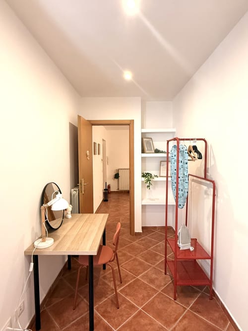 Moderno spazio di lavoro in camera da letto presso Castelli Apartments con scrivania, sedia, specchio e attaccapanni rosso ad Albano Laziale