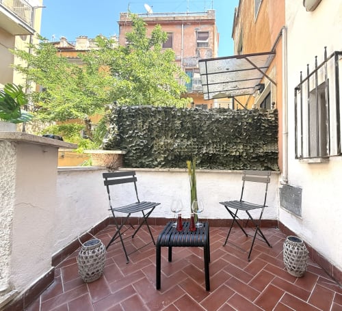 Affascinante terrazza sul tetto degli Appartamenti Castelli ad Albano Laziale con sedute, piante in vaso e vista sulla città