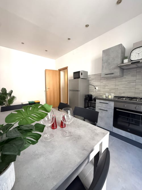 Cucina e zona pranzo moderne presso la residenza familiare Castelli Apartments ad Albano Laziale con elettrodomestici in acciaio inox e