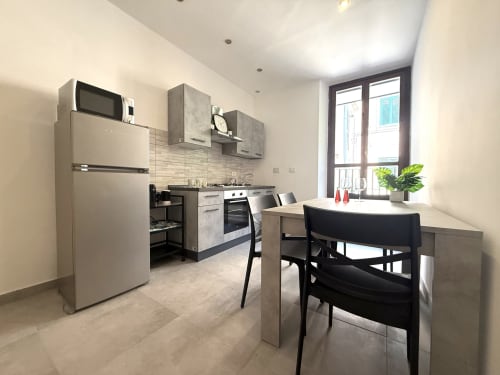 Zona cucina-pranzo moderna negli Castelli Apartments Family Home con elettrodomestici in acciaio inox, tavolo da pranzo e vista sulla città