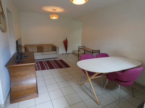 Espace de vie moderne avec table à manger, chaises violettes, canapé beige et parquet chez Sci Ludji Nanterre