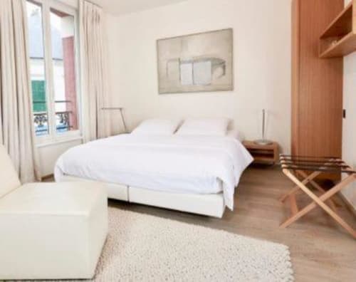 Chambre Supérieure lumineuse à l'Hidden Bay Hotel avec lit blanc, parquet, vue sur la ville et mobilier contemporain