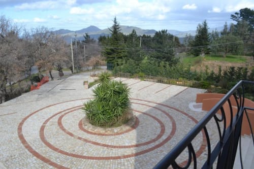 Terrazza con motivo in pietra circolare e pianta verde, Hotel Ristorante alle Querce, Castelbuono, viste montane
