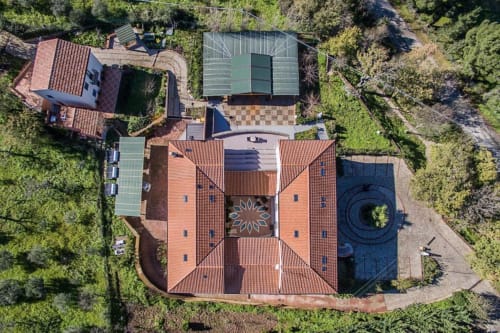 Vista aerea dell'Hotel Ristorante alle Querce a Castelbuono con tetti in cotto e verdeggiante circondario