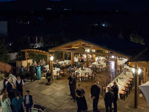 Ricevimento serale di matrimonio all'Hotel Ristorante alle Querce a Castelbuono, ospiti che cenano sotto il padiglione in legno