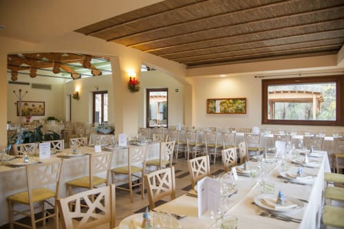 Elegante sala da pranzo dell'Hotel Ristorante alle Querce a Castelbuono con sedie bianche e tavoli apparecchiati