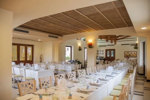 Elegante sala banchetti dell'Hotel Ristorante alle Querce di Castelbuono con tovaglie bianche, travi in legno e atmosfera formale