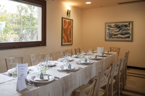 Elegante sala da pranzo dell'Hotel Ristorante alle Querce a Castelbuono con tavoli formalmente apparecchiati e opere d'arte contemporanea