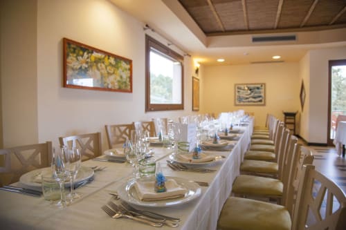Elegante sala da pranzo dell'Hotel Ristorante alle Querce a Castelbuono con tavoli elegantemente preparati, tovaglie bianche e sedie in legno