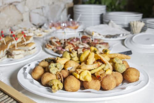 Fritti dorati e polpettone panato con patatine alle erbe su piatti bianchi all'Hotel Ristorante alle Querce,