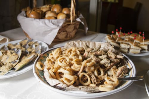 Assortimento di antipasti e pasticcini all'Hotel Ristorante alle Querce di Castelbuono, con anelli di cipolla e stuzzichini italiani