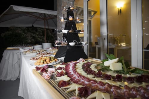 Elegante buffet serale all'aperto presso l'Hotel Ristorante alle Querce con salumi, formaggi e display tiered di antipasti