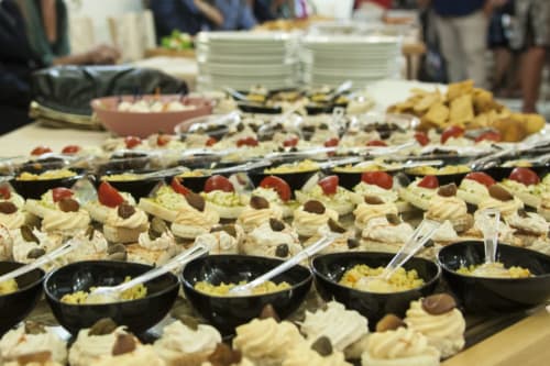 Tavolo di catering presso l'Hotel Ristorante alle Querce a Castelbuono con antipasti, piatti di pasta e ciotole nere di salsa