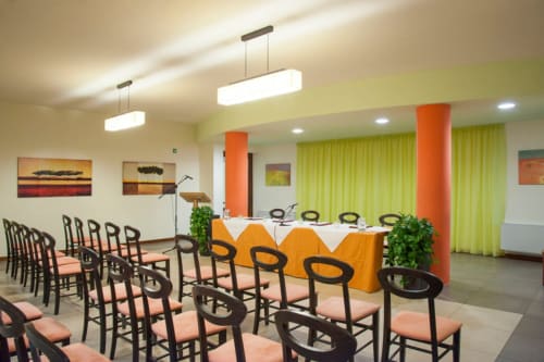 Sala banchetti Hotel Ristorante alle Querce con illuminazione moderna, accenti arancioni e allestimento elegante a Castelbuono