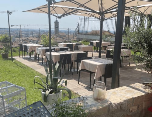The Kraken Inn Bergamo terrace with shaded dining tables overlooking Italian countryside