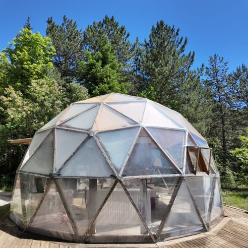 Le dôme géodésique La Bulle de l'hôtel spa La Font Vineuse entouré de pins à Saint-Pierre-d'Argençon