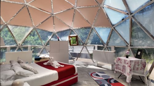 La chambre dome La Bulle à la Spa Hotel La Font Vineuse avec vue sur le jardin, lit, architecture moderne et terrasse