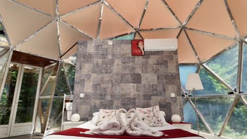 La chambre dôme géodésique La Bulle du Spa Hôtel La Font Vineuse avec coussins en forme de cœur et vue sur le jardin