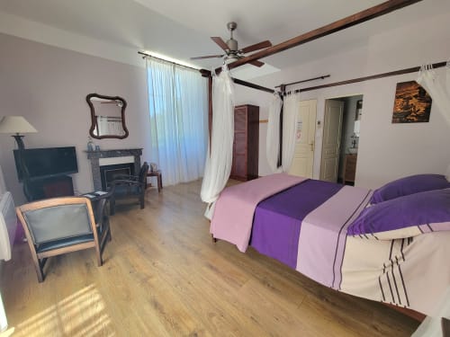 Chambre Violette au Cadran Solaire à Courcelles : spacieuse chambre avec lit à baldaquin, linge de lit pourpre, cheminée et plafond