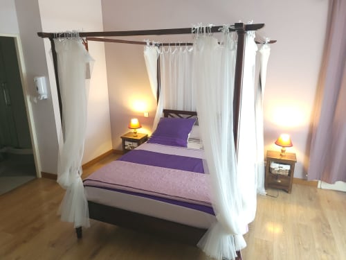 Lit à baldaquin Chambre Violette avec parure violette et voilages blancs à Le Cadran Solaire, Courcelles