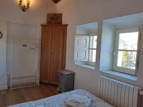 Camera da letto in Chalet Maxi Momosa, villa di Ovindoli con armadio in legno, letto in metallo, finestre e riscaldamento a radiatori