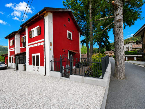 Chalet alpino rosso e bianco a Ovindoli con vista sulle montagne, ingresso indipendente e terrazza giardino