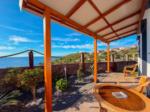 Terraço com pérgolado de madeira e vista para o oceano na villa Casa do Pico em Funchal, Portugal, com vista para a costa atlântica
