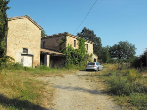Agriturismo La Frattina in Buonconvento, Siena - rustic Tuscan farmhouse with ivy-covered stone walls and countryside setting