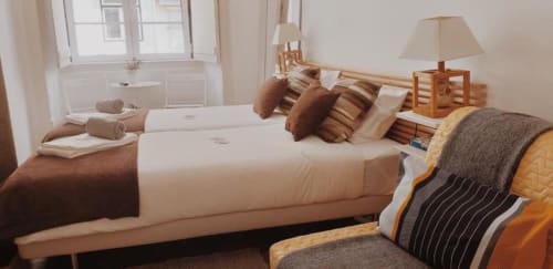 Spacious two-bedroom apartment in Lisbon with twin beds, brown and cream bedding, wooden furnishings, and city view from
