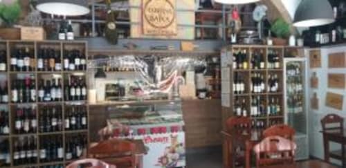 Wine bar and restaurant interior at Charm Discovery Experiences BnB in Lisbon with wooden shelving and city views