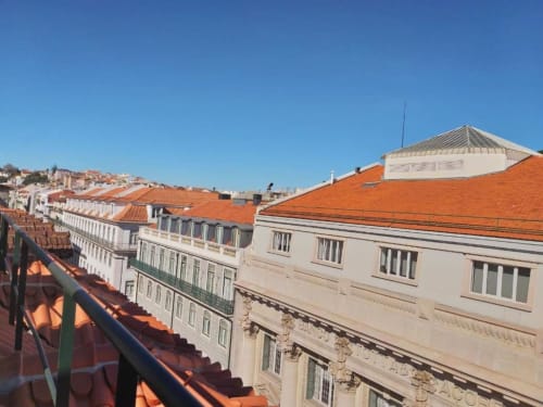 Lisbon city view from apartment balcony overlooking terracotta roofed buildings and urban skyline